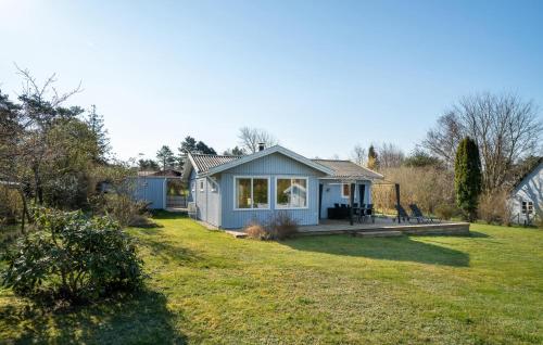 a small blue house in a garden with a yard at Lovely Home In Melby With Kitchen in Melby