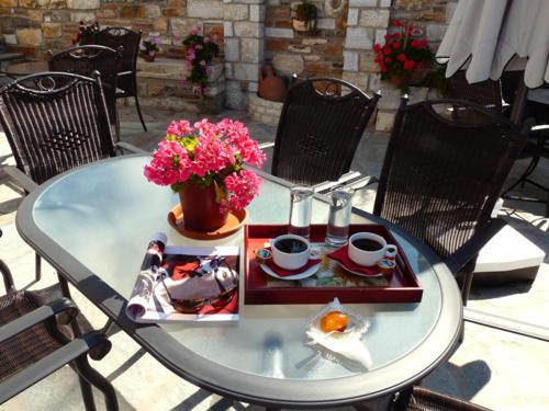 a table with a plate of food and flowers on it at Hotel Ilianna in Portaria