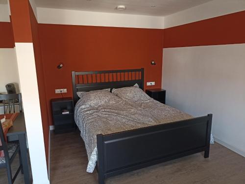 a bedroom with a bed with orange walls at Klooster Achthuizen in Achthuizen