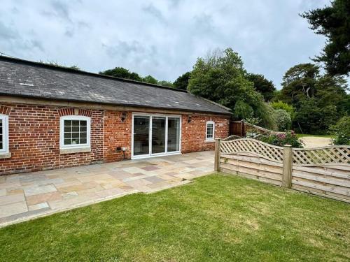 a brick house with a fence and a yard at Countryside Apartment in Trowbridge