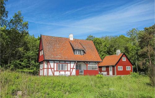 a red and white house in the middle of a field at Awesome Home In Gudhjem With Wifi in Gudhjem