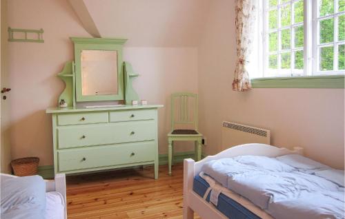 a bedroom with a bed and a dresser with a mirror at Awesome Home In Gudhjem With Wifi in Gudhjem