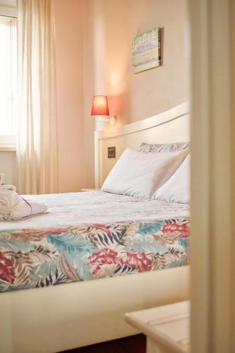 a bedroom with a bed with a colorful blanket at Le Bignele in Marano di Valpolicella