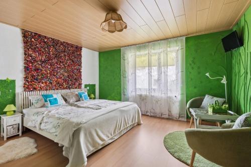 a bedroom with green walls and a large bed at Gästehaus Margerite in Blieskastel