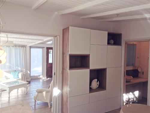 un salon avec des armoires blanches et une pièce avec une table dans l'établissement Rivages Palladio, à Saint-Raphaël