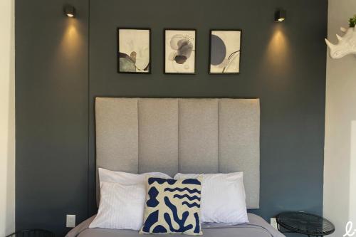 a bedroom with a bed with three pictures on the wall at Lapso At Alarcón in Guadalajara