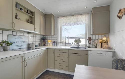 a kitchen with white cabinets and a window at Lovely Home In Gudhjem With Wifi in Gudhjem
