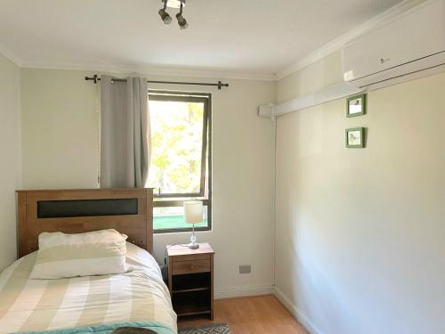 a bedroom with a bed and a window at Full departamento, Metro Manquehue, Las Condes in Santiago
