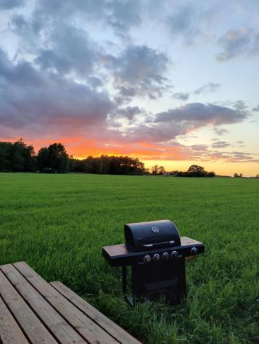 a grill sitting on a picnic table next to a field at Under Canvas Bornholm in Østermarie