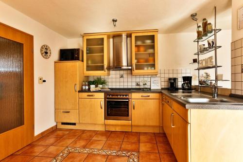 a kitchen with wooden cabinets and a sink at Ferienhaus Kottmann in Bremerhaven