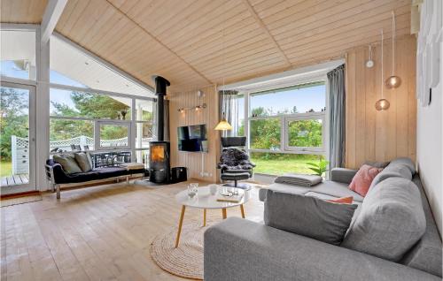 a living room with a couch and a table at Holiday Home Mågelunden Rødby I in Kramnitse
