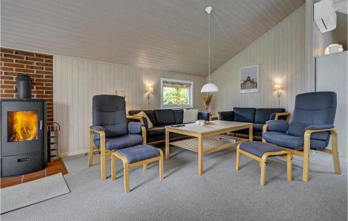 a living room with blue chairs and a fireplace at Holiday Home Filosofstræde Dannemare V in Dannemare