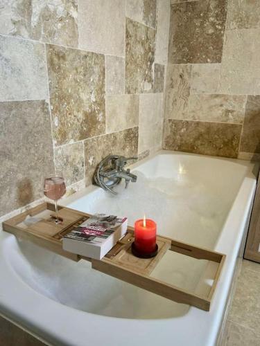 une bougie posée sur un plateau dans une baignoire dans l'établissement Villa paradis Maison piscine chauffé, à Barbentane