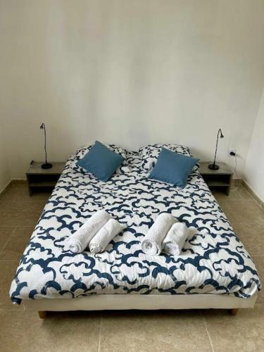 un lit avec des draps et des oreillers bleus et blancs dans l'établissement Villa paradis Maison piscine chauffé, à Barbentane