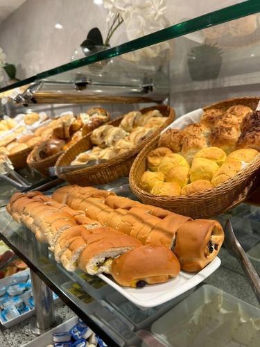 a display case with various types of pastries and bread at Residencial Sausalito in Rio de Janeiro