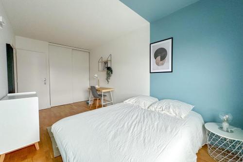 une chambre avec un lit blanc et une table dans l'établissement Flexliving - room - Hillairet, à Paris