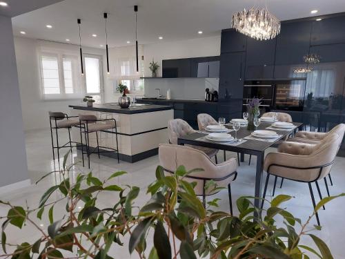 a kitchen and dining room with a table and chairs at Berenát Villa in Nyíregyháza
