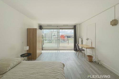 une chambre avec un lit, un bureau et une fenêtre dans l'établissement Flexliving - room - Mouchez, à Paris