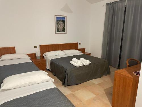 a hotel room with two beds with towels on them at La Locanda del Brigante in Farindola