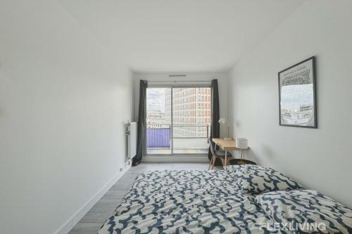 une chambre blanche avec un lit et une fenêtre dans l'établissement Flexliving - room - Mouchez, à Paris