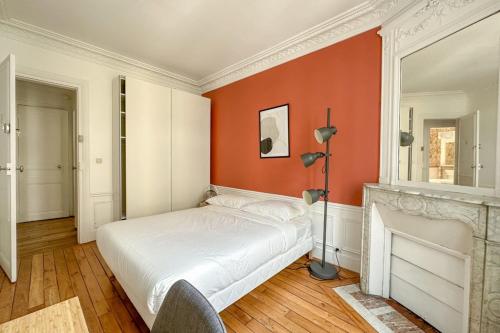 a bedroom with a white bed and a fireplace at Flexliving - room - Hameau in Paris