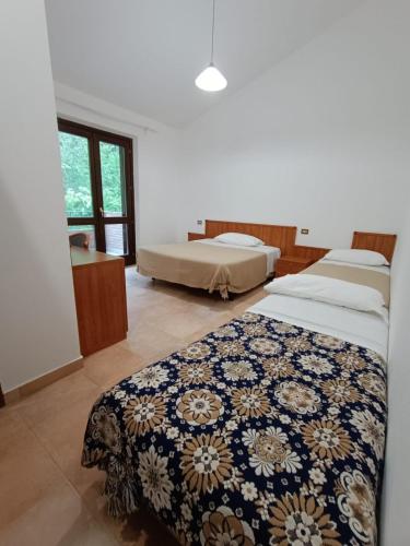 a bedroom with two beds and a window at La Locanda del Brigante in Farindola