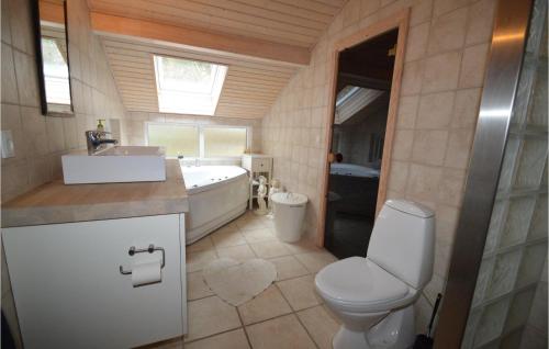 a bathroom with a toilet and a tub and a sink at Three-Bedroom Holiday Home In Lundby in Lundby