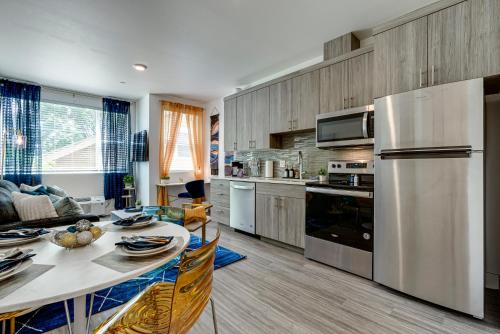 a kitchen with a dining table and a refrigerator at Bright & Cozy Walkable Alberta Condo, Fast WiFi, & Quite in Portland