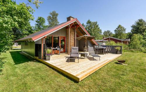 a house with a deck with chairs and a table at Holiday Home Silkeborg 11 Denmark in Abildskov