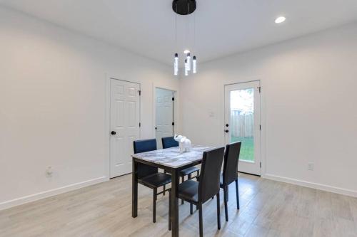 a dining room with a black table and chairs at Lé Luxe Maison -3BR 2 BA- Medical Center and Downtown HTX in Houston