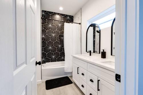 a white bathroom with a sink and a mirror at Lé Luxe Maison -3BR 2 BA- Medical Center and Downtown HTX in Houston