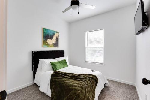 a white bedroom with a bed and a ceiling fan at Lé Luxe Maison -3BR 2 BA- Medical Center and Downtown HTX in Houston