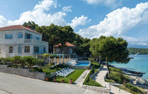 dom z basenem obok wody w obiekcie Apartment Koludrt Bb Croatia w mieście Lumbarda