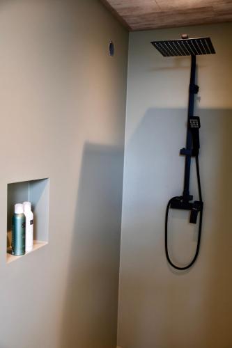 a bathroom with a hair dryer hanging on the wall at De Reiziger in Stavele