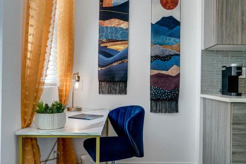 a desk with a blue chair and paintings on the wall at Bright & Cozy Walkable Alberta Condo, Fast WiFi, & Quite in Portland