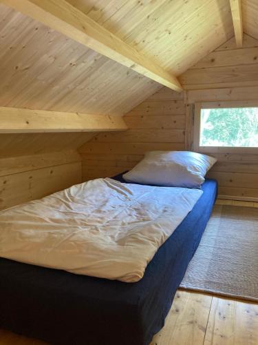 un lit dans une chambre avec un plafond en bois dans l'établissement Tiny House am See, à Casel