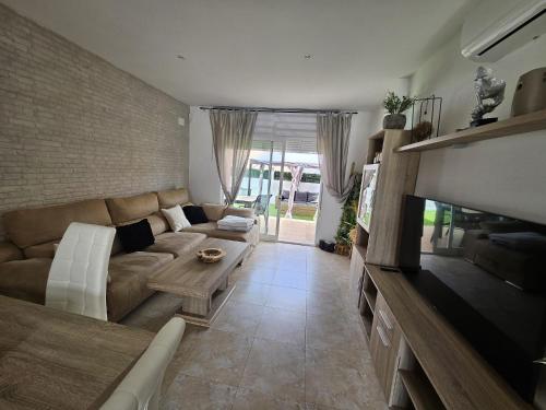 Una sala de estar con un sofá y un televisor. en La casa Latina, en Vinarós
