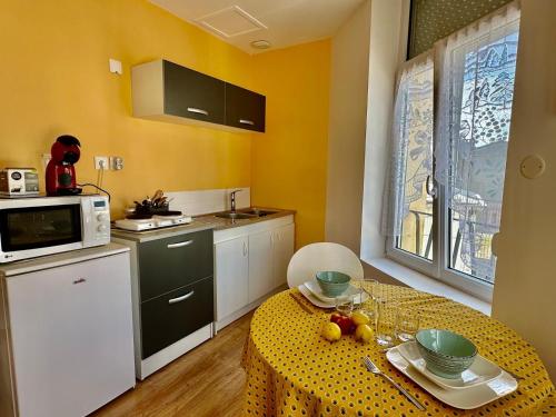 une petite cuisine avec une table et un micro-ondes dans l'établissement La Capucine, à Berck-sur-Mer