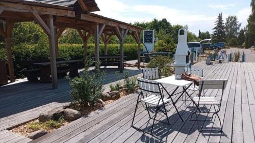 eine Holzterrasse mit Stühlen und einem Tisch darauf in der Unterkunft Ferienwohnung 2 Personen Hund willkommen in Lütow