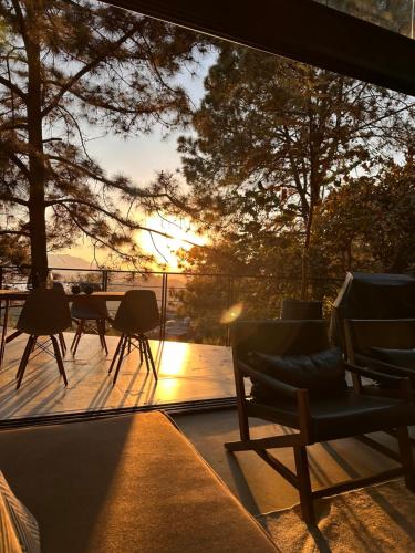 a view of a deck with chairs and a sunset at Tosanva Valle de Bravo in Toluca