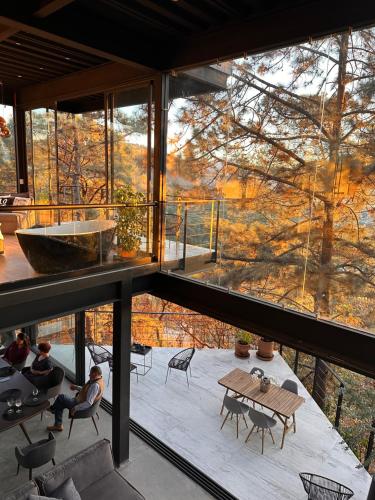 a room with a large window and a table and chairs at Tosanva Valle de Bravo in Toluca