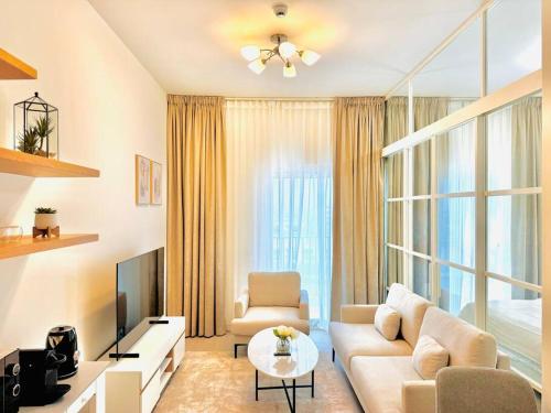 a living room with a couch and a tv at Golfville LighthouseDubai Hills in Dubai