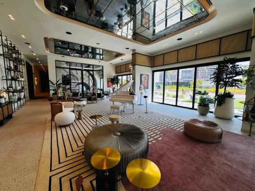 a large room with a lobby with tables and chairs at Golfville LighthouseDubai Hills in Dubai