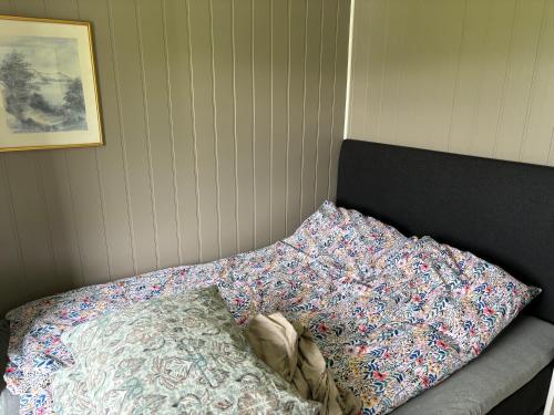 a bed with a pillow next to a wall at Harstad, all seasons in Harstad