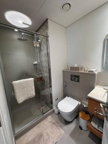 a bathroom with a shower and a toilet at Golfville LighthouseDubai Hills in Dubai