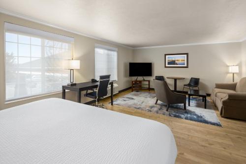 a hotel room with a bed and a desk and a tv at Ramada by Wyndham Moses Lake in Moses Lake