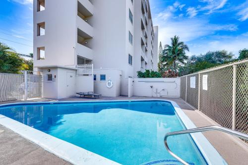 a swimming pool in front of a building at Kailua-Kona Condo with Balcony Walk to the Beach! in Kailua-Kona