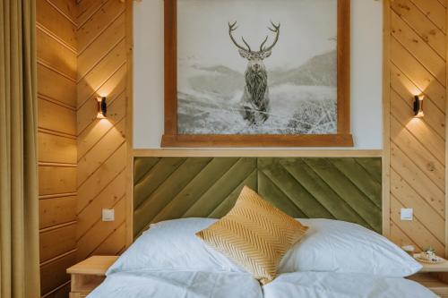 a bedroom with a bed with a picture of a deer at "Podhalański Gościniec" -250 m Gorący Potok ,Termy Szaflary in Szaflary