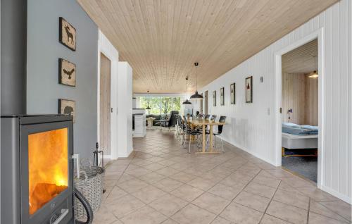 a living room with a fireplace and a dining room at Holiday Home Illeris Xi in Hvalpsund