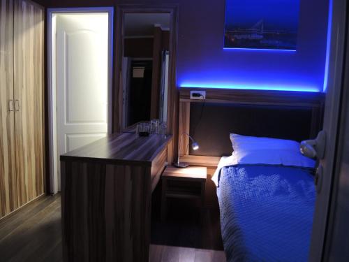 a bedroom with a bed and a vanity with a blue light at Apartments 43 in Krnjača